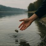 湖に石を投げて水面に波紋が広がる様子を捉えた静かな風景写真